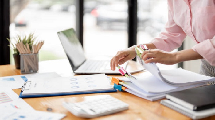 une femme travaillant sur un bureau administratif - externaliser des services administratifs - Activ Solutions