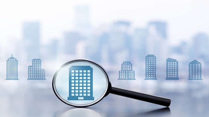 Loupe et plusieurs icônes de bâtiments sur fond de paysage urbain - louer un espace de coworking - Activ Solutions