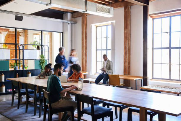 Groupe diversifié d'hommes et de femmes d'affaires travaillant ensemble dans un espace ouvert d'un bureau - bureaux de coworking - Activ Solutions