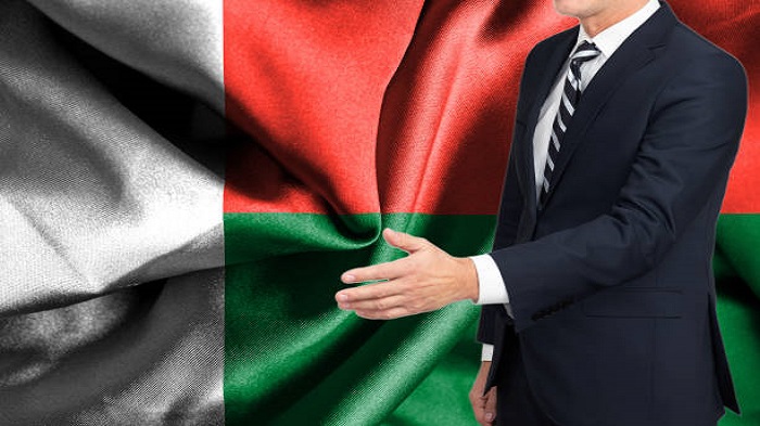un homme d'affaires anonyme et un drapeau de Madagascar - création de société à Madagascar - Activ Solutions