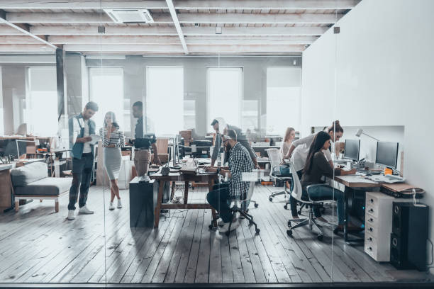 Groupe de jeunes travaillant ensemble dans un bureau créatif - location de bureau dédié