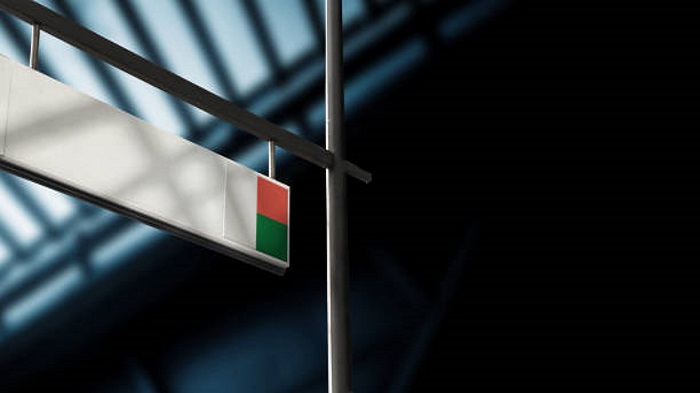 Drapeau de Madagascar sur le panneau d'information des départs à l'aéroport - Externalisation des entreprises - Activ Solutions